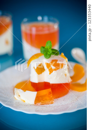 Bright jelly with pieces of peaches and milk jelly on a blue background 123353440