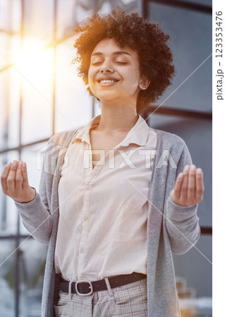 Portrait of young mulatto lady practising yoga at her work place during the break Portrait of young mulatto lady practising yoga at her work place during the break 123353476