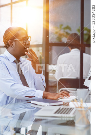 a man at a workplace at a table in front of a computer is surprised by the good news 123354282