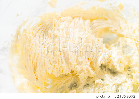 In a large mixing bowl, the ingredients are expertly mixed to create a delectable cream cheese buttercream for the Carrot Bundt Cake. 123355072
