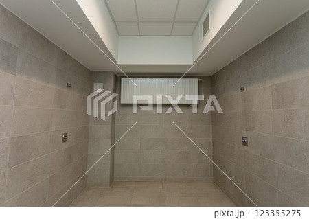 A spacious and vacant concrete room, featuring a skylight above and proper ventilation systems, A spacious and vacant concrete room, featuring a skylight above and proper ventilation systems, 123355275