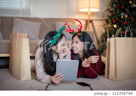 Lesbian Couple Celebrates Christmas with Digital Devices and Festive Laughter Lesbian Couple Celebrates Christmas with Digital Devices and Festive Laughter 123356794