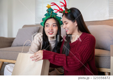 Tender Moment Between Interracial Lesbian Couple During Festive Gift Sharing 123356872