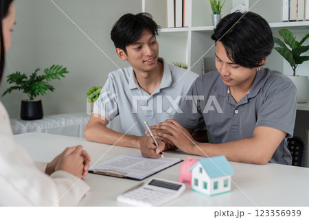 Same Sex Couple Signing Papers with Financial Advisor 123356939