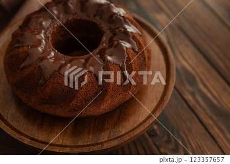 Chocolate cake with chocolate icing on dark wooden table. Low key. Top view Chocolate cake with chocolate icing on dark wooden table. Low key. Top view 123357657
