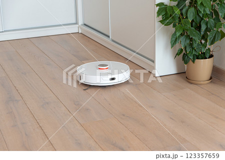 Robot vacuum cleaner vacuuming dust at room. Natural sunny lights 123357659