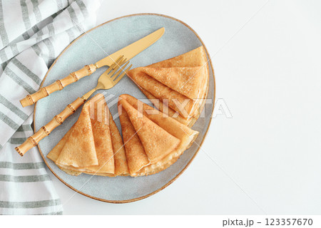 Golden crepes on white wooden table. Pancake day, Maslenitsa. Top view 123357670