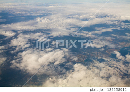 beautiful thick clouds in the sky from the height of the flight of the plane with a view of the continent and countries 123358912
