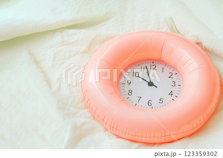 inflatable swimming circle with alarm clock on a light background 123359302