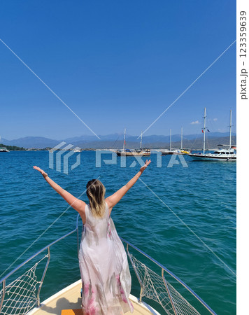 beautiful girl on the deck of a boat while traveling on the sea with a view of the mountains 123359639