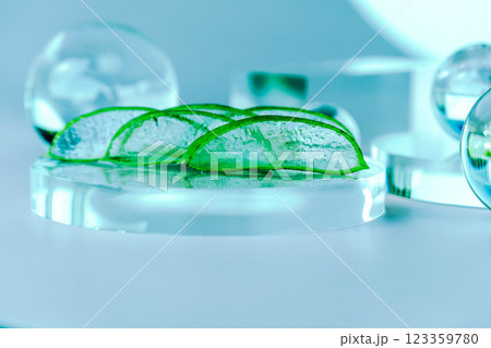 Aloe slices rest on a glass base surrounded by clear spheres, creating a calming spa atmosphere. Aloe slices rest on a glass base surrounded by clear spheres, creating a calming spa atmosphere. 123359780