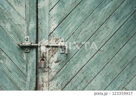 old metal lock on a wooden door with cracked paint old metal lock on a wooden door with cracked paint 123359917