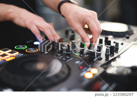 a DJ plays music on a controller at a party 123360207