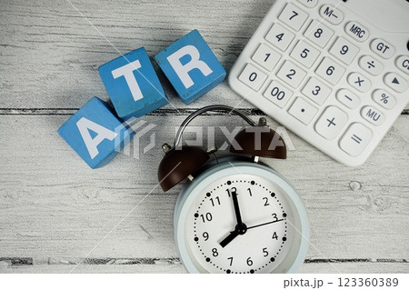 ATR (Average True Range) text with alarm clock and calculator on wooden background ATR (Average True Range) text with alarm clock and calculator on wooden background 123360389