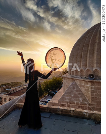 silhouette of a girl with a shamanic drum near Sultan Isa Medrese Mosque in Turkey silhouette of a girl with a shamanic drum near Sultan Isa Medrese Mosque in Turkey 123360478