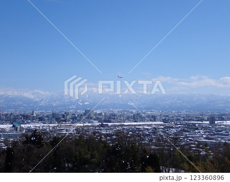 2025年2月25日雪景色の富山市街地と冠雪の北アルプ氏と旅客機 123360896