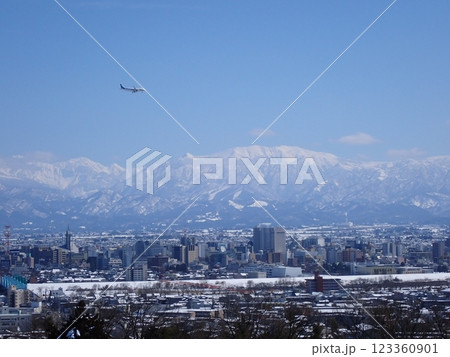 2025年2月25日雪景色の富山市街地と冠雪の北アルプ氏と旅客機 123360901