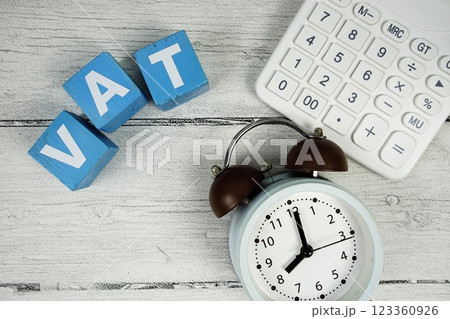 VAT (Value Added Tax) text with alarm clock and calculator on wooden background 123360926