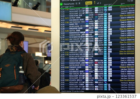 空港の時刻表を確認する旅行客 飛行機の時刻表 空港の時刻表を確認する旅行客 飛行機の時刻表 123361537