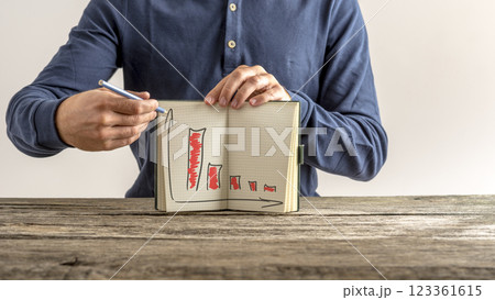 Businessman showing his notebook with falling financial graphs 123361615
