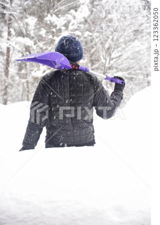 田舎で雪の降る中除雪をしている元気な老人 123362050