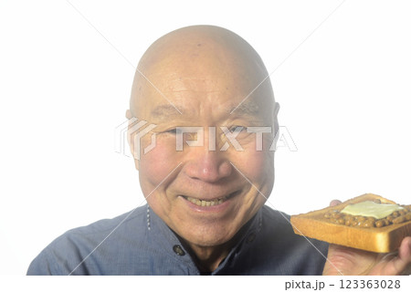 トーストした食パンを笑顔で食べる老人 トーストした食パンを笑顔で食べる老人 123363028