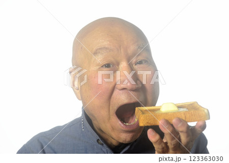 トーストした食パンを笑顔で食べる老人 123363030