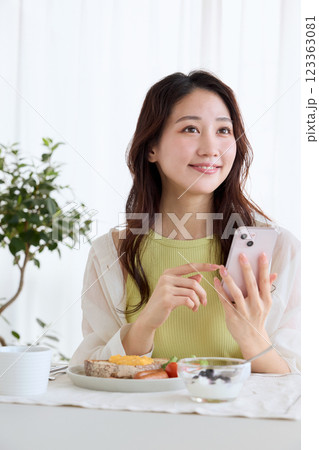 ダイニングで朝ごはんを食べる女性 123363081