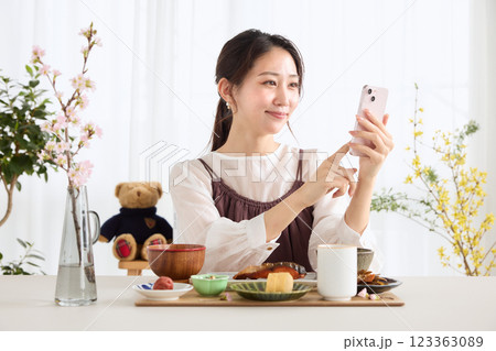 朝食にスマートフォンを見る女性 朝食にスマートフォンを見る女性 123363089