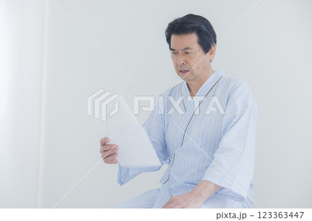 検査結果を見てショックを受ける中年男性 123363447