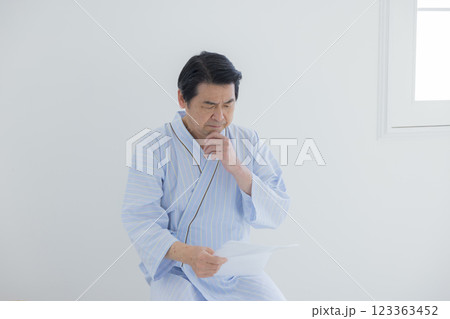検査結果を見てショックを受ける中年男性 123363452