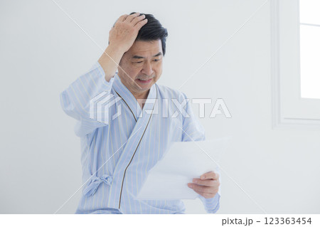 検査結果を見てショックを受ける中年男性 123363454