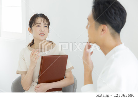 エステティシャンの女性にカウンセリングを受ける男性 エステティシャンの女性にカウンセリングを受ける男性 123363680