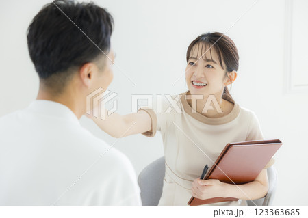 エステティシャンの女性にカウンセリングを受ける男性 エステティシャンの女性にカウンセリングを受ける男性 123363685