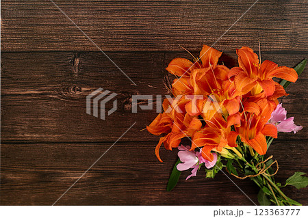 Bouquet of lily and mallow flowers on wooden background, summer and autumn banner for product advertising, abstract floral arrangement, rustic style, holiday card, selective focus. Bouquet of lily and mallow flowers on wooden background, summer and autumn banner for product advertising, abstract floral arrangement, rustic style, holiday card, selective focus. 123363777