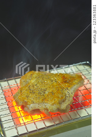 煙り立ち昇る七輪で鶏もも肉を焼く 123363881