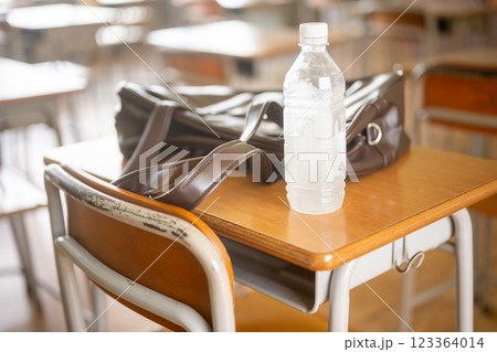 学校の机の上に置かれた凍ったペットボトルとカバン 123364014
