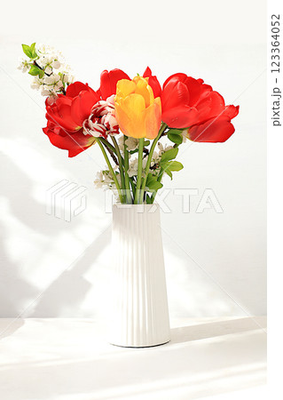 Beautiful spring flowers tulips in a vase on a sunny background, banner. Abstract flower arrangement, still life with space for text, floral holiday card, summer greeting concept, selective focus 123364052