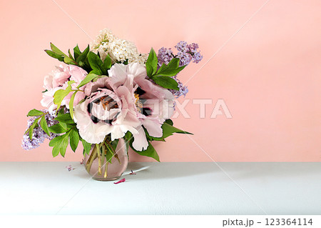 Abstract floral arrangement, home interior with beautiful spring mountain peonies and lilac branches in a vase, spring banner, still life with space for text, floral holiday card, selective focus 123364114