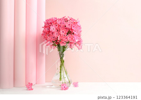 Home interior with decor elements, beautiful phlox flowers in a vase on a light background, abstract flower composition, still life with place for text, floral card for birthday, wedding, selective 123364191