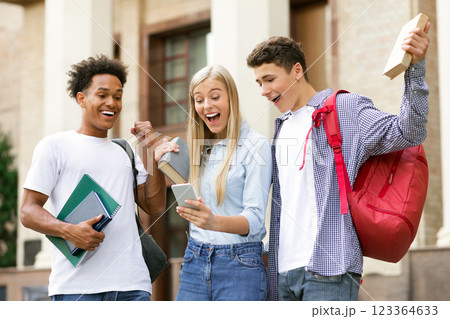 Excellent marks. Surprised students checking exam results online on smartphone 123364633