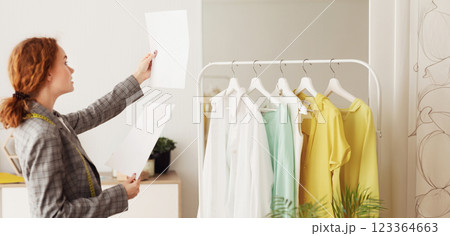 Young Designer Checking And Comparing Sketches On Papers, Working In Tailor Studio 123364663