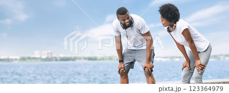 Running And Coaching. African American Couple Catching Breath Resting After Morning Jog Along River Embankment. Copy Space 123364979
