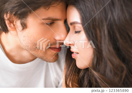 This is a close-up portrait of a man and a woman about to kiss. They are looking into each others eyes and appear to be in love. This is a close-up portrait of a man and a woman about to kiss. They are looking into each others eyes and appear to be in love. 123365890