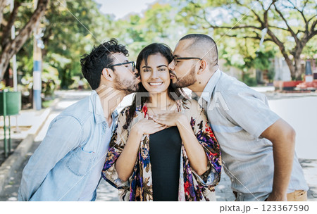 Two men kissing a girl cheek. Portrait of two guys kissing a girl cheek. Two young men kissing a woman cheek outdoor, love triangle concept. Polygamy concept 123367590