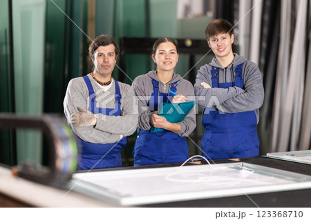 Two men and woman working in glass factory Two men and woman working in glass factory 123368710