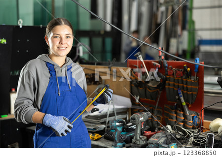 Young woman with tape measure in workshop Young woman with tape measure in workshop 123368850