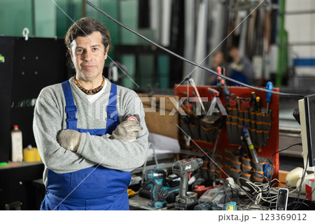 Adult man with tape measure in workshop Adult man with tape measure in workshop 123369012