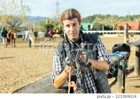 Owner of the stable poses in front of corral for horses Owner of the stable poses in front of corral for horses 123369014