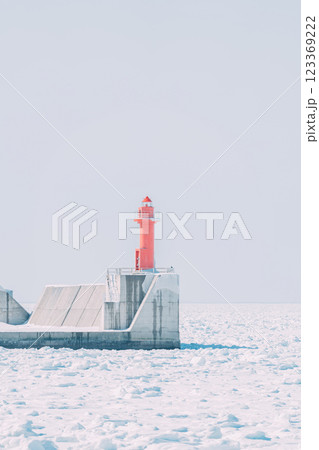冬の青空と流氷に覆われた赤い灯台 123369222